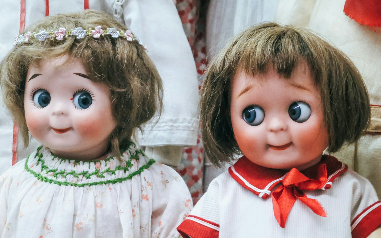 An antique porcelain doll with a pristine face and dress, next to a modern customized doll with repainted features and alternative clothing, illustrating the choice between preservation and alteration.