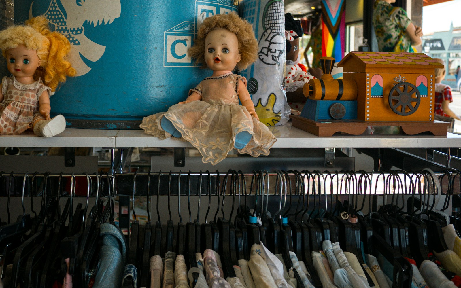 Close-up of vintage plush dolls on a shelf with soft lighting, showing careful storage.