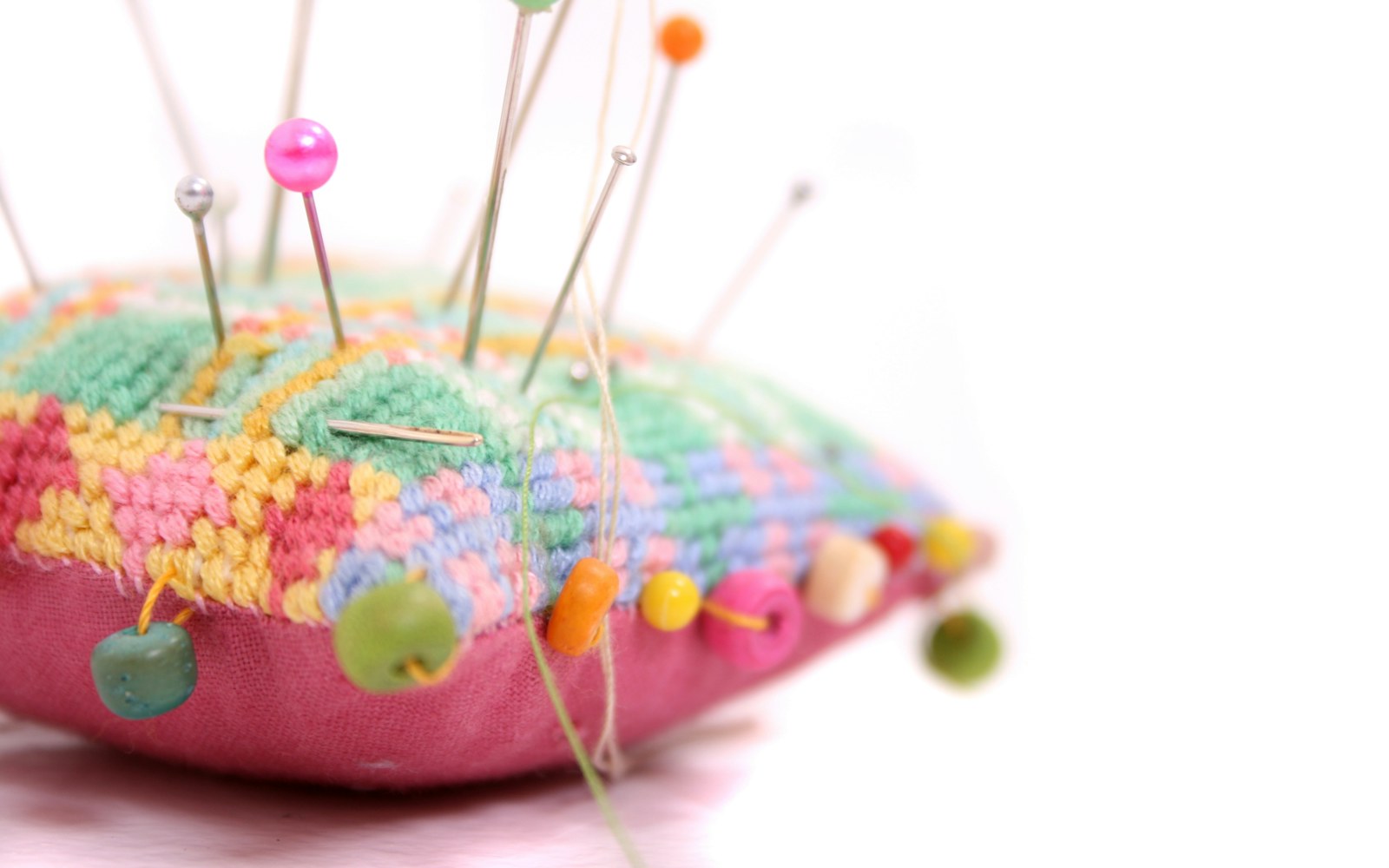 Close-up of a hand-sewn doll's head showing irregular stitch patterns and asymmetrical embroidered eyes