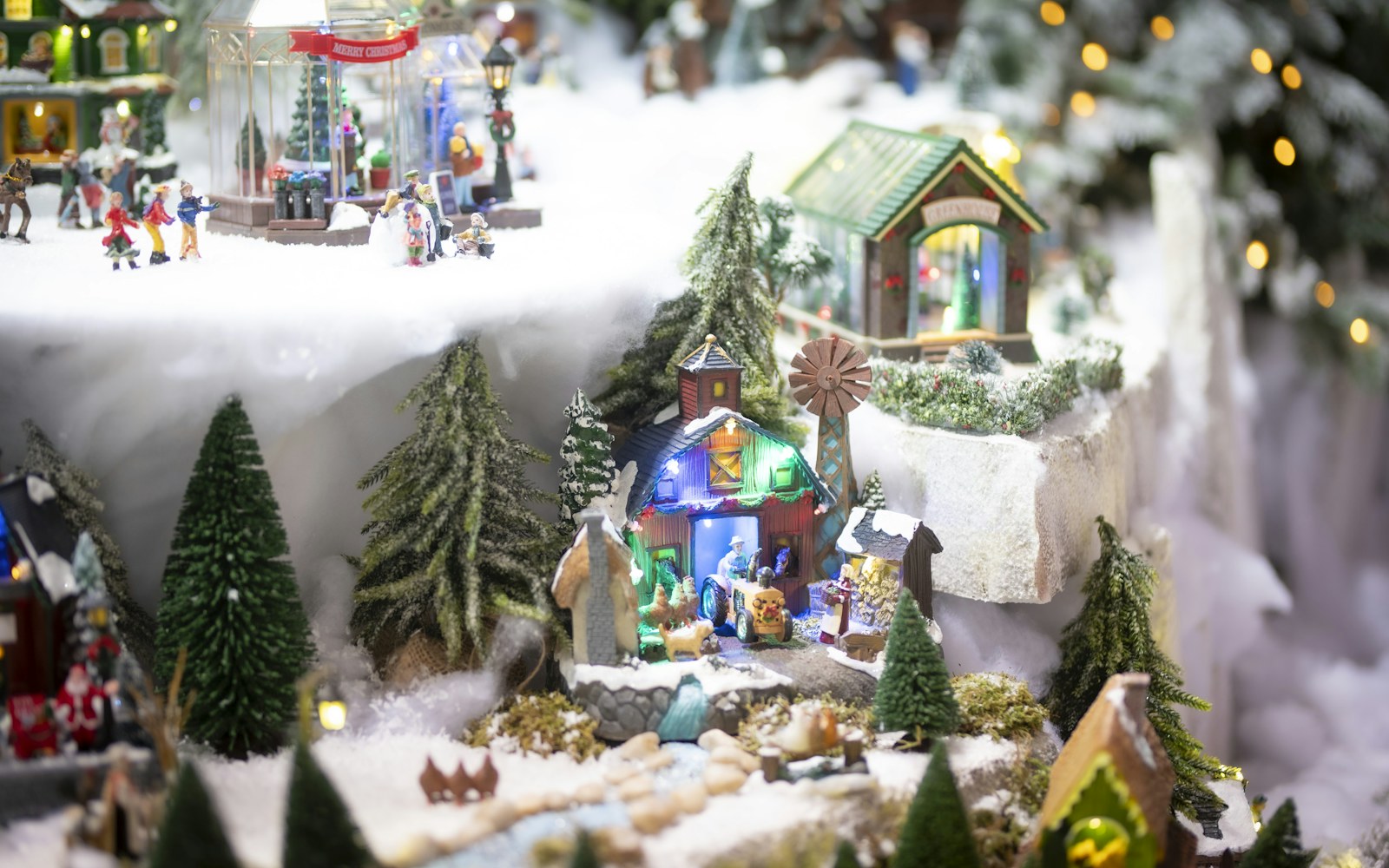 A handmade miniature diorama with a softly illuminated window and concealed LED wiring in its wooden base, with an art doll positioned safely inside.