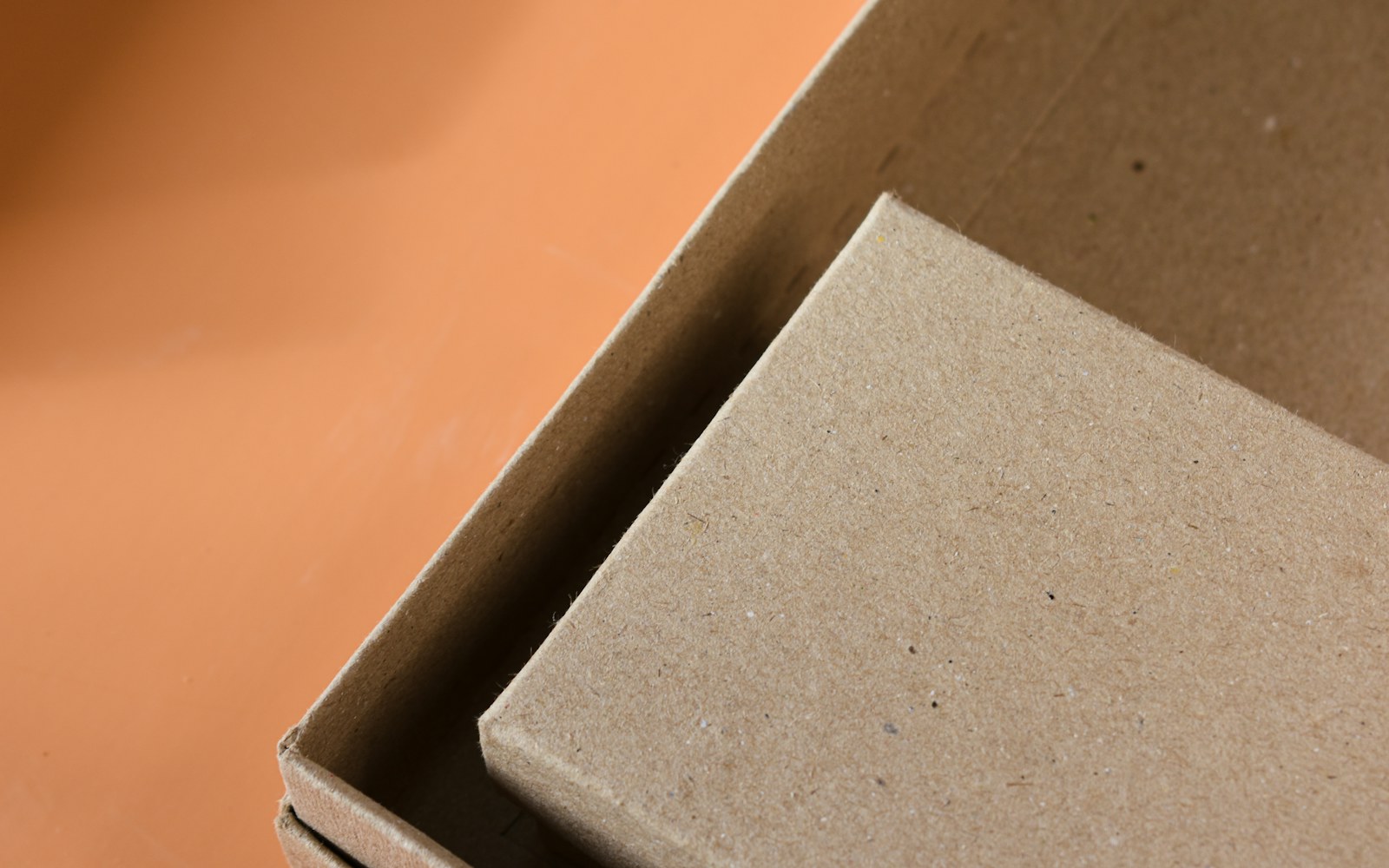 A handmade textile art doll resting in a lined storage box with soft supports arranged around its limbs and head.