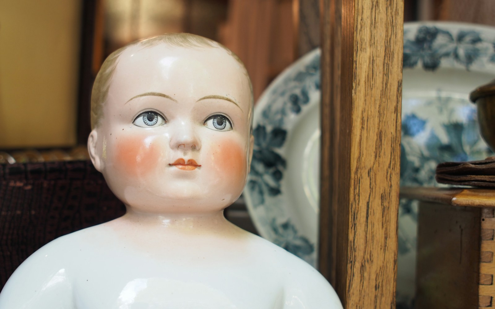 Close-up of a ceramic doll's face with an uneven, milky glaze surface, showing translucency issues